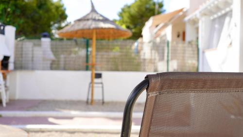una silla y una sombrilla frente a una valla en Casa Uly 2, en Riumar