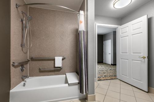 a bathroom with a tub and a shower and a toilet at La Quinta by Wyndham Belton - Temple South in Belton