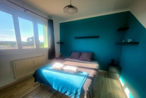une chambre avec un lit avec un mur bleu dans l'établissement Aiglon YourHostHelper, à Saint-Raphaël