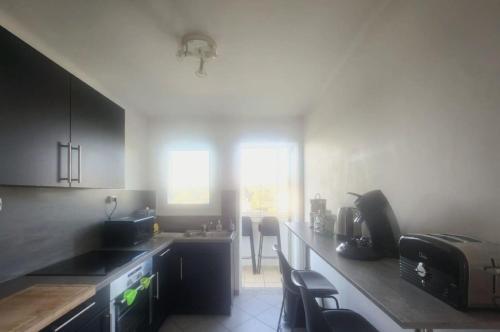 une cuisine avec des armoires noires et un comptoir dans l'établissement Aiglon YourHostHelper, à Saint-Raphaël