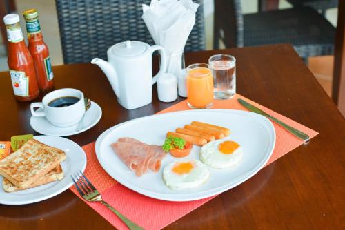 een tafel met een bord eieren, ham en toast bij Krabi Front Bay Resort in Krabi town