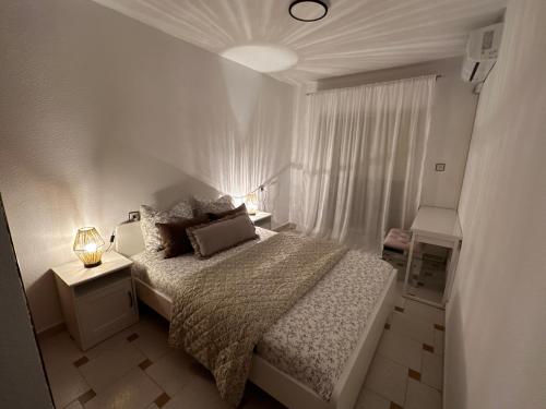 a white bedroom with a bed and a window at Maison Lo pagan San Pedro del pinatar murcia in San Pedro del Pinatar