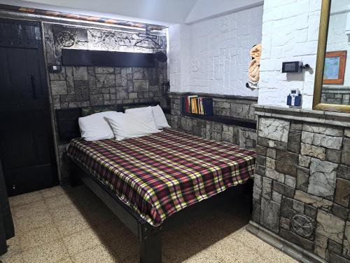 a small bed in a room with a stone wall at Casa Jazz in Salinas
