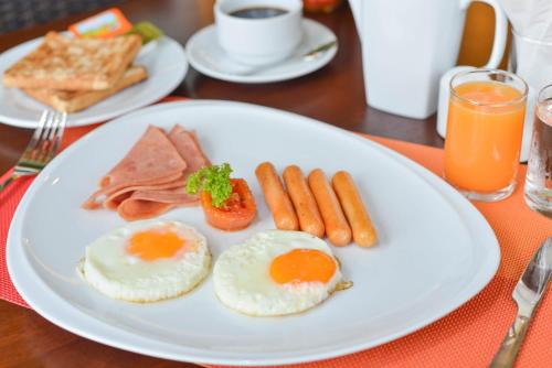 een wit bord met eieren, worst en toast bij Krabi Front Bay Resort in Krabi town