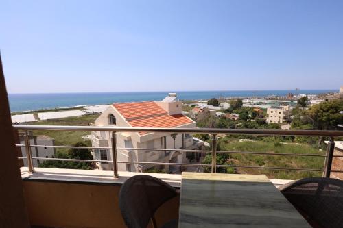 een balkon met een tafel en stoelen en de oceaan bij Ibiza Hotel in Jounieh