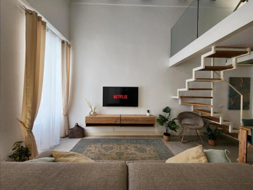 ein Wohnzimmer mit einem Sofa und einem TV an der Wand in der Unterkunft CLASSY HOMES - Acquamarina in Sanremo