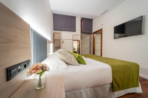 a bedroom with a white bed with a vase of flowers at SAHERA HOTEL Boutique in Telde