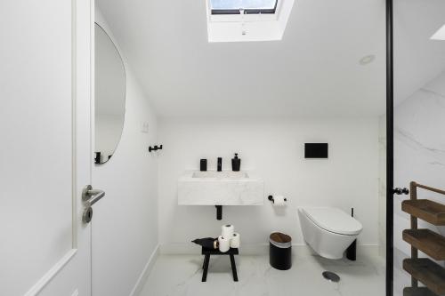 a white bathroom with a sink and a toilet at WHome Brand New Lisbon Rooftop with River View in Lisbon