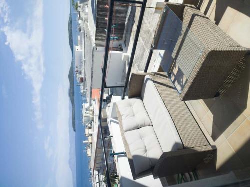 una vista aérea de un balcón con sillas blancas en un edificio en SEAgull apartments en Néa Péramos