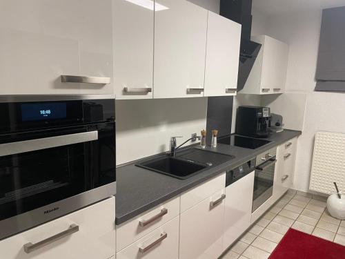 a white kitchen with a sink and a microwave at Dream Place in Iserlohn in Iserlohn
