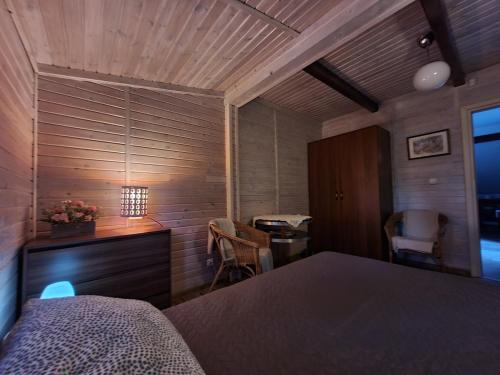 a bedroom with a bed and a desk and chairs at Dom Nad Jeziorem in Szteklin