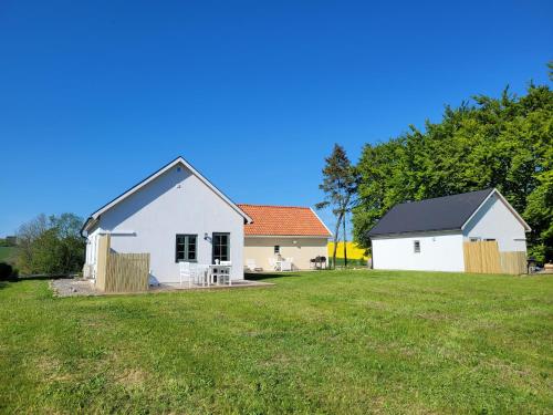 a white house and a house with a yard at Litet hus i mysig by nära havet in Ystad