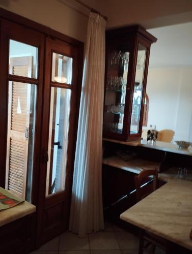 a kitchen with a wooden cabinet and a window at Zeusplace karia Villa Natura in Leptokaria