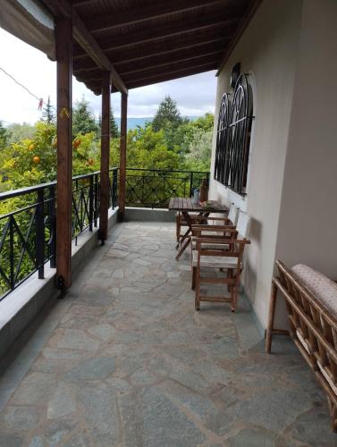 a patio with a table and chairs on a balcony at Zeusplace karia Villa Natura in Leptokaria