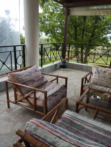 a porch with two chairs and a coffee table at Zeusplace karia Villa Natura in Leptokaria