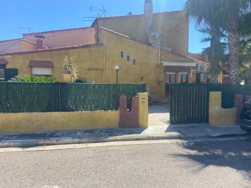 a yellow fence in front of a house with a building at Villa Azzurra Fronte Mare in Capitana