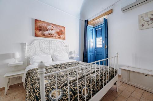een slaapkamer met een bed en een blauwe deur bij Casa Demetra in Siracusa