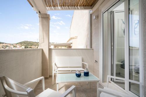 a small balcony with a table and chairs at Su Mari Rooms in Villasimius
