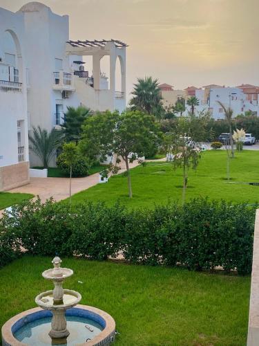 a fountain in the grass in front of a building at Marina Saidia AP8 LILIA in Saidia 