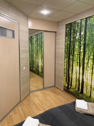 a room with a large window with a forest view at Saimaa Apartment in Lappeenranta