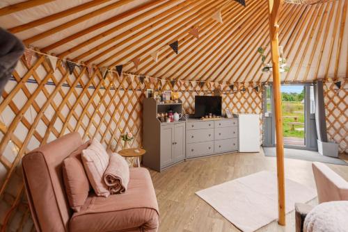 a living room with a couch in a yurt at Glamp and Tipple Ltd in Great Ellingham