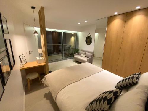 une chambre avec un lit, un bureau et une chaise dans l'établissement Appartement luxe vue mer et collines avec piscine, à Mandelieu-la-Napoule