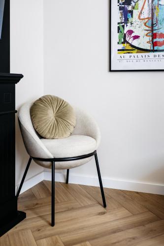 a white chair with a pillow on it in a room at Park Home with Free Street Parking in Győr
