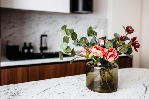a vase filled with pink roses sitting on a counter at Park Home with Free Street Parking in Győr