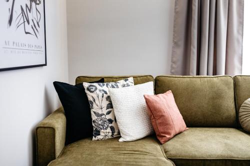 a couch with pillows on it in a living room at Park Home with Free Street Parking in Győr