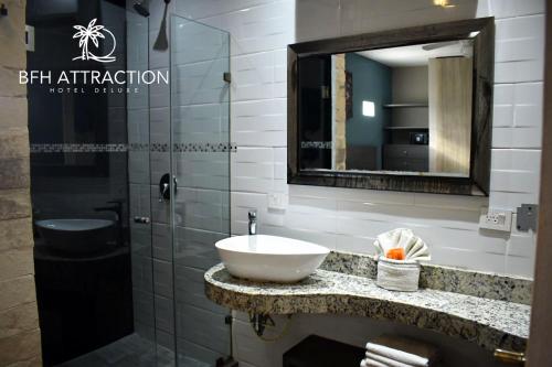a bathroom with a sink and a mirror at Attraction Hotel Deluxe in Playa del Carmen