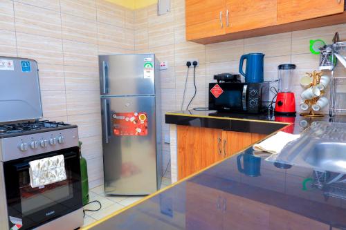 a kitchen with a stainless steel refrigerator and a stove at EDD'S HOME AWAY FROM HOME in Kisii