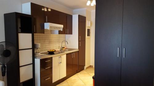 eine Küche mit braunen Schränken und einer weißen Arbeitsplatte in der Unterkunft Frontière direct Monaco Studio en Résidence in Beausoleil