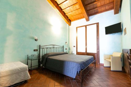 a bedroom with a bed and a television in a room at Il Podere Del Germano Reale in Coriano