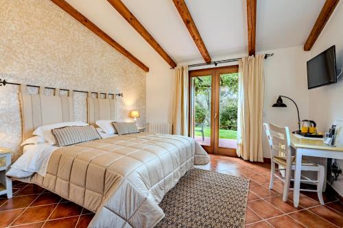 1 dormitorio con cama, mesa y escritorio en Tenuta Pilastru Country Resort & Spa en Arzachena