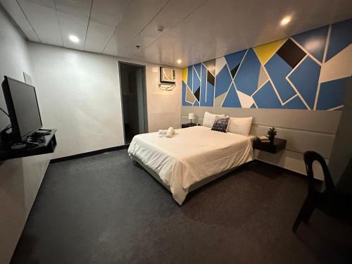Tempat tidur dalam kamar di ACME Inn Subic