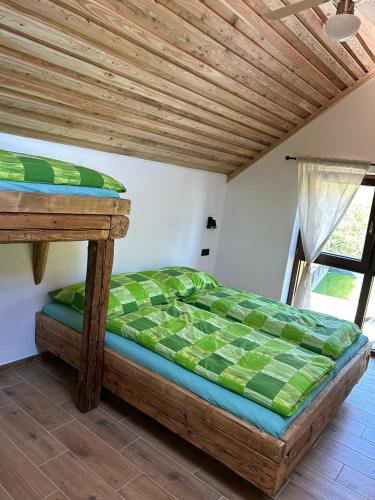 a bed in a room with a wooden ceiling at Penzion s rafty in Vyšší Brod
