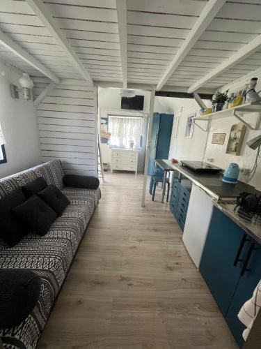 a living room with a couch and a kitchen at Domek Rybaka in Gąski