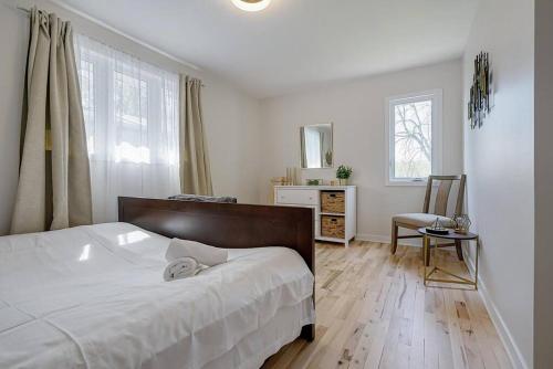 um quarto com uma cama, uma secretária e uma janela em La Riviera - Cottage in the City em Gatineau