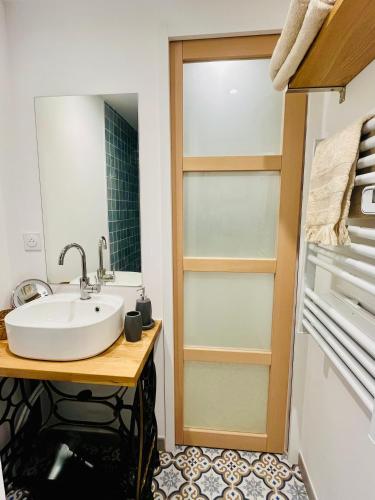 une salle de bain avec un lavabo et un miroir dans l'établissement Joli appartement refait à neuf, au Tholonet