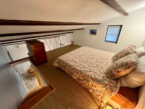 - une chambre mansardée avec un lit et un miroir dans l'établissement Joli appartement refait à neuf, au Tholonet