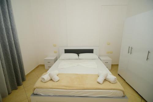 a bedroom with a bed with towels on it at Harris&Arvien Apartment's in Vlorë