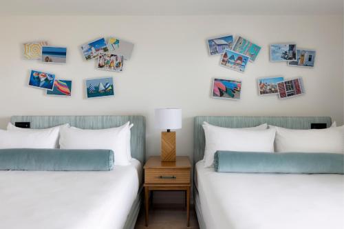 Red Jacket Beach Resort في جنوب يارماوث: سريرين في غرفة نوم مع صور على الحائط