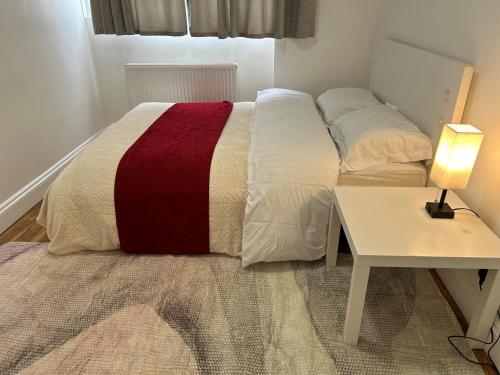 a bedroom with a bed with a red and white blanket at London City Inn Stepney in London