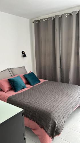 サン・バルトロメにあるPool Front Playmar Maspalomasのベッドルーム1室(ピンクとブルーの枕が備わるベッド1台付)