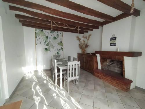 une salle à manger avec une table et une cheminée dans l'établissement Maison Berrichonne, 6 pers, à Écueillé