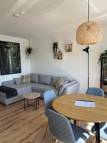 een woonkamer met een bank en een tafel bij Up Wulkje21 Neu renovierte Wohnung mit PKW Stellplatz in Emden