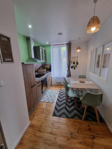 une cuisine avec une table et des chaises dans une pièce dans l'établissement Les flocons enchantés, neuf, belle vue,4 personnes, à La Bourboule