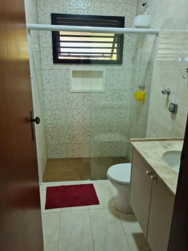 a bathroom with a toilet and a sink and a window at Chácara Santo Antonio in Brotas