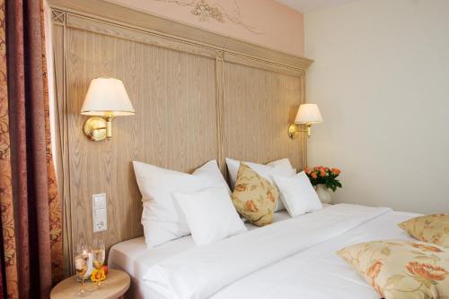 a hotel room with a bed with white pillows at Hotel Rebstock in Baden-Baden