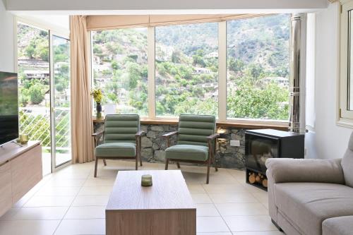 a living room with a couch and chairs and a fireplace at Oikou Thea Guesthouse in Oikos